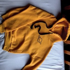 cropped yellow sweatshirt with black planet icon